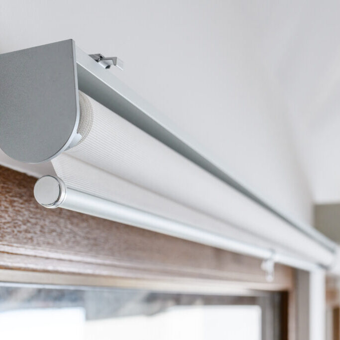 Roller blinds on apartment window, closeup with selective focus