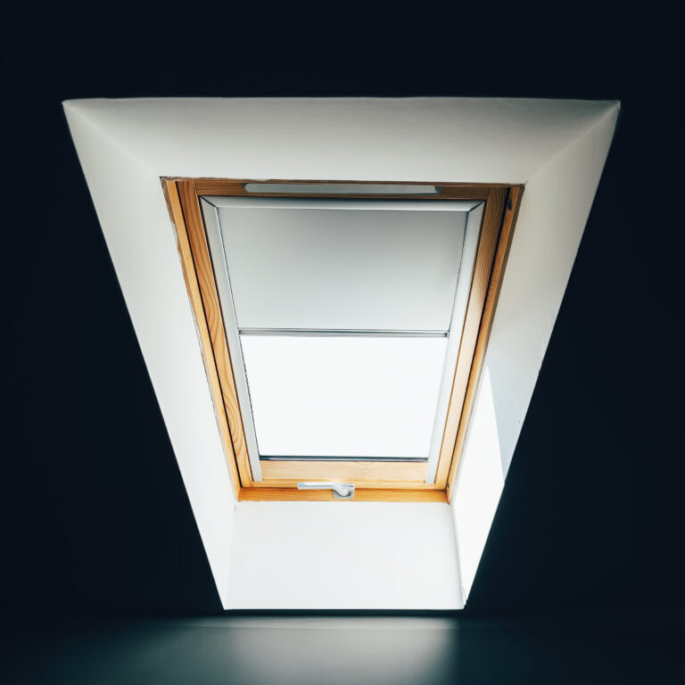 Roof window in winter seen from the dark room interior